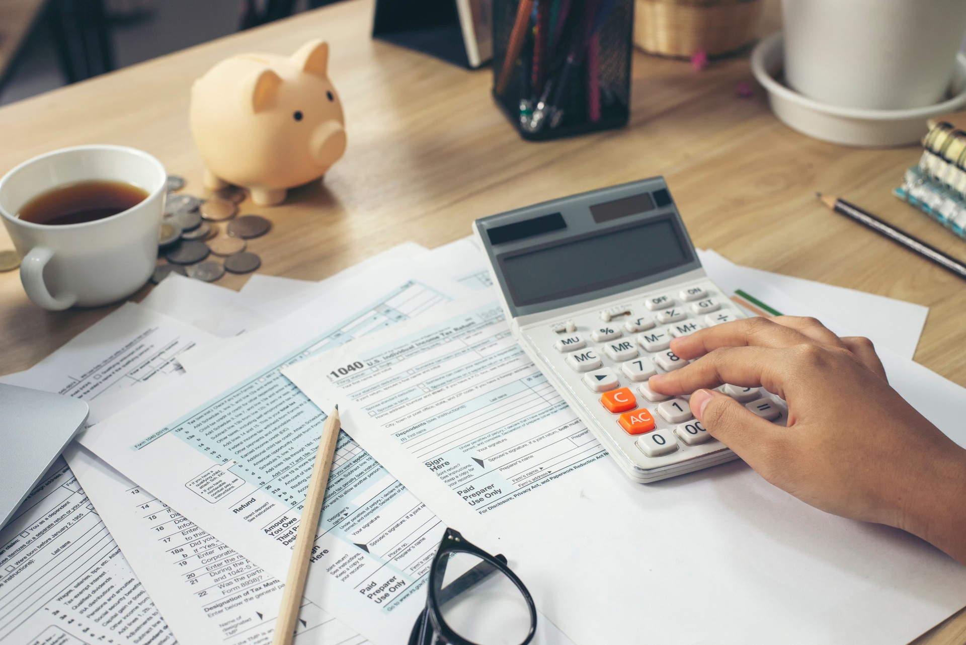 Budget and Tax planning concept. Hand's Accountant is calculating company annual tax. Personal income 1040 tax form for who have income under US law, season to pay tax.