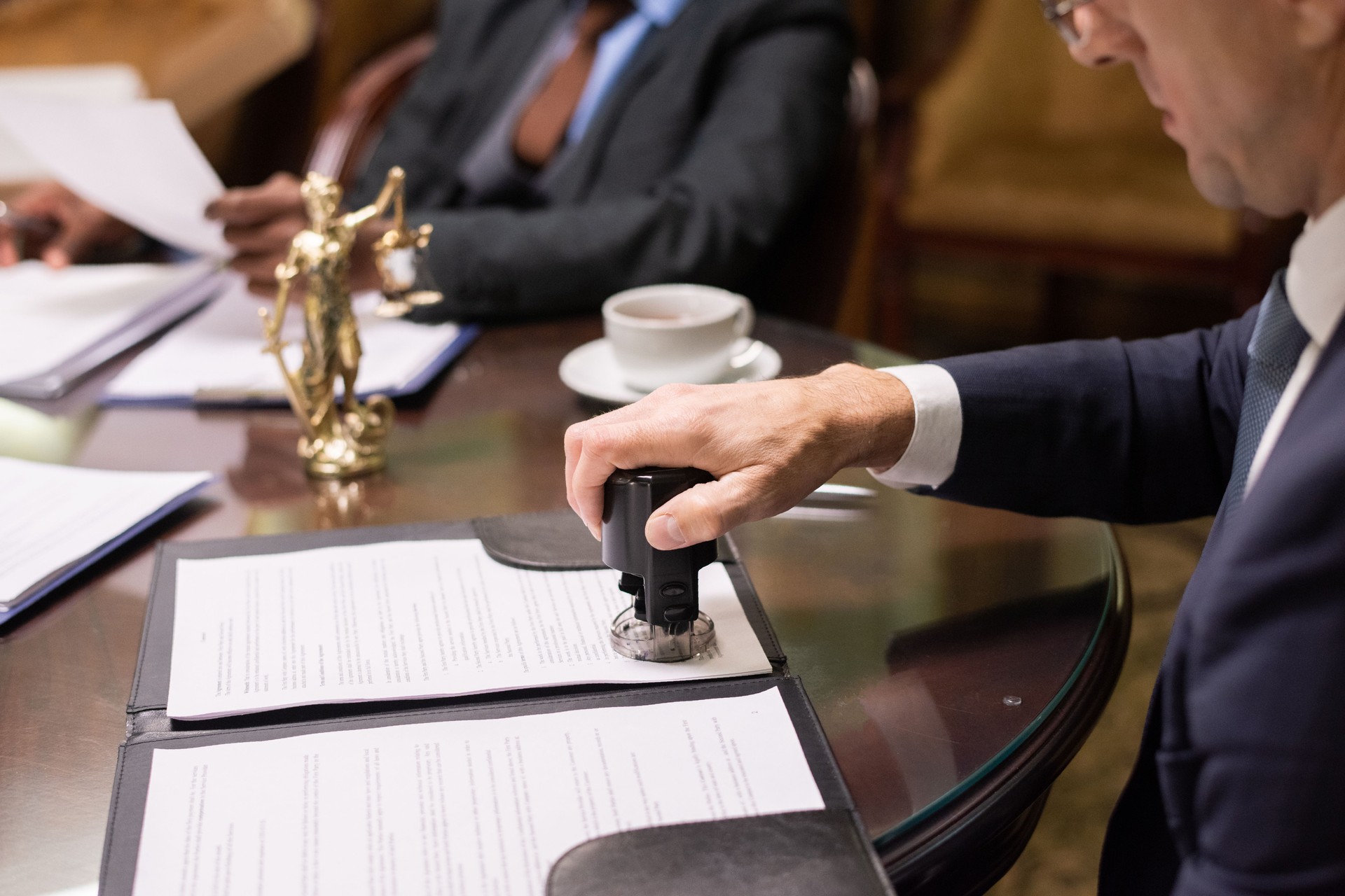 Hand of director of company putting stamp on document